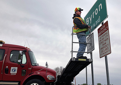 Photo: Loren Tews updates population on Byron sign.